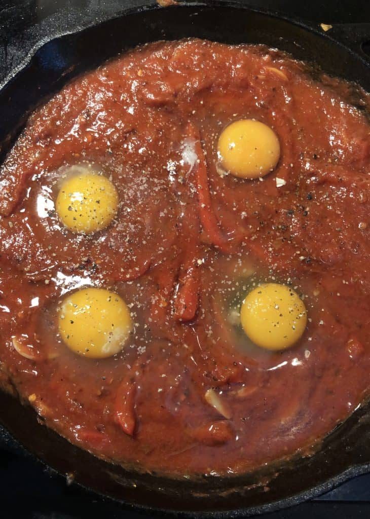 Με μια κουτάλα ανοίξτε 4 μικρά πηγαδάκια στη σάλτσα και ρίξτε εκεί μέσα τα αυγά. | mantemi.gr